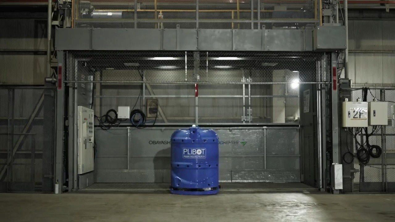 PLiBOTで統合制御されたエレベーターから自動的に降りてくる湿式清掃ロボット（写真：PLiBOT）