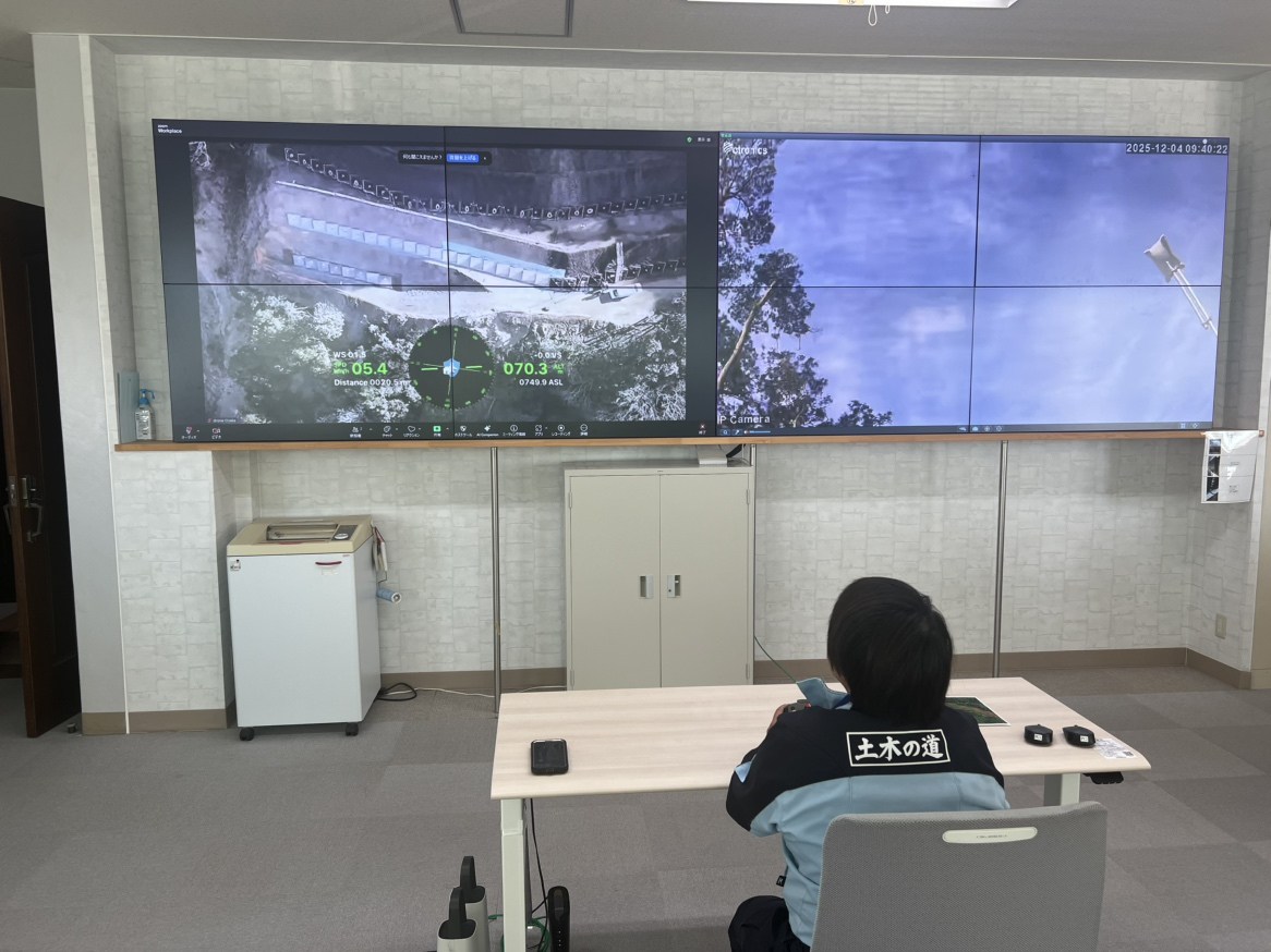 現場から35km離れた本社オフィスで、ドローンを遠隔操作するパイロット。右側は俯瞰カメラからの映像