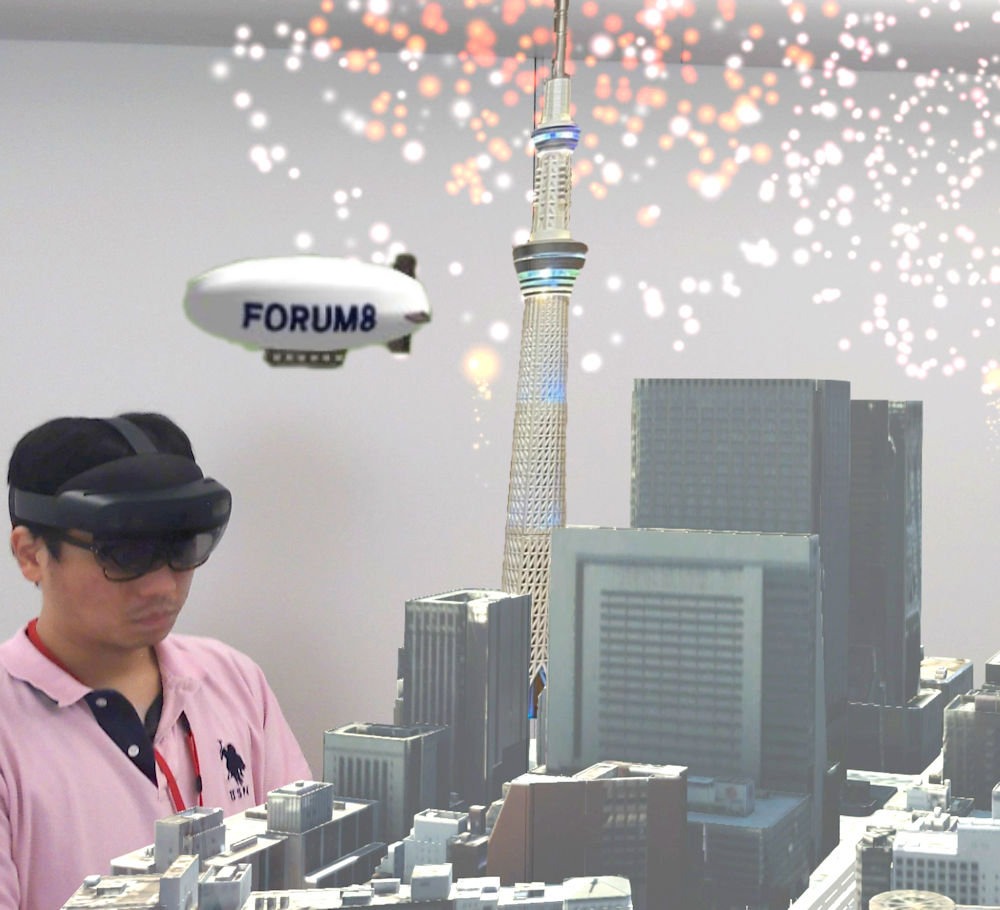 3Dプリンターで作った日本橋の模型や、東京スカイツリーの模型の上空で「バーチャル花火大会」を行います。HoloLensを通して見ると、まるでホンモノの街に花火が上がっているみたい！ 手持ち花火を使ったダイナミックな飛行船ゲームも楽しめますよ。（協力：インフォマティクス、フォーラムエイト）
